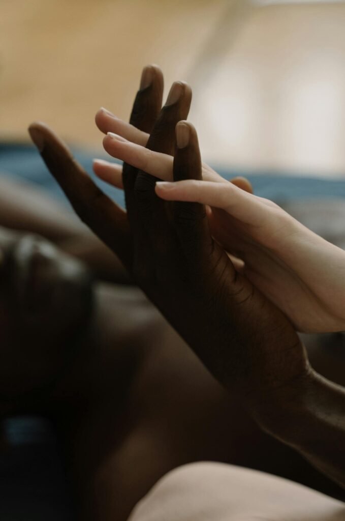 Close-up of an interracial couple's hands intertwined, symbolizing love and unity.